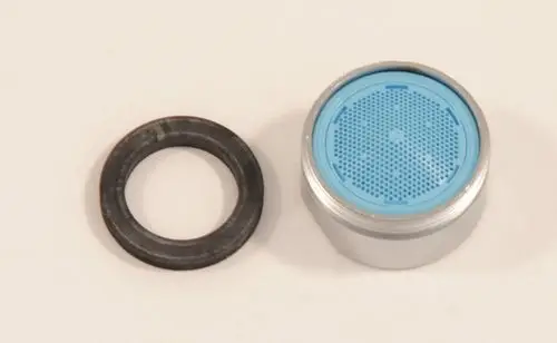 Strahlregler von Ideal Standard, bestehend aus einem zylindrischen Element mit feinem Lochmuster und einem Dichtungsring, auf hellem Hintergrund.